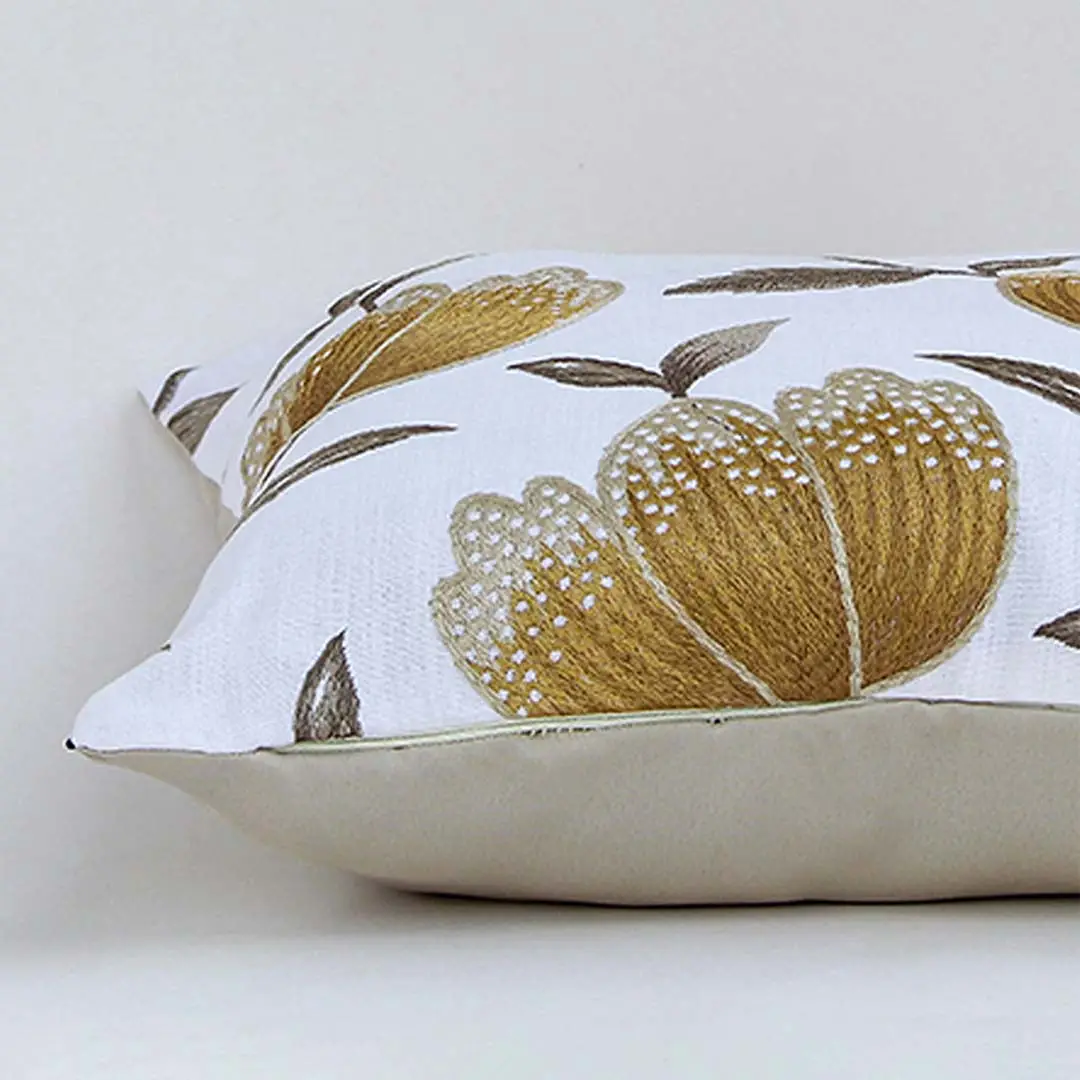 White cotton cushion cover with oversized mustard botanical leaf print showcasing soft fabric texture and premium stitching details.