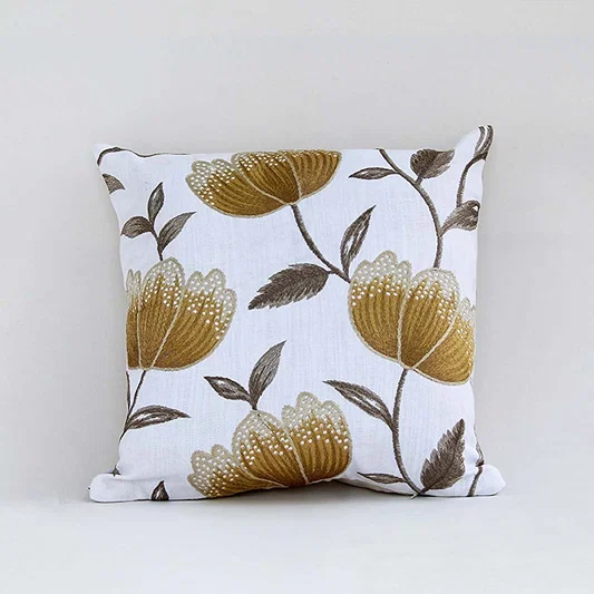 White cotton cushion cover with large golden botanical motifs providing a premium nature inspired décor accent with a breathable soft and skin friendly material finish.