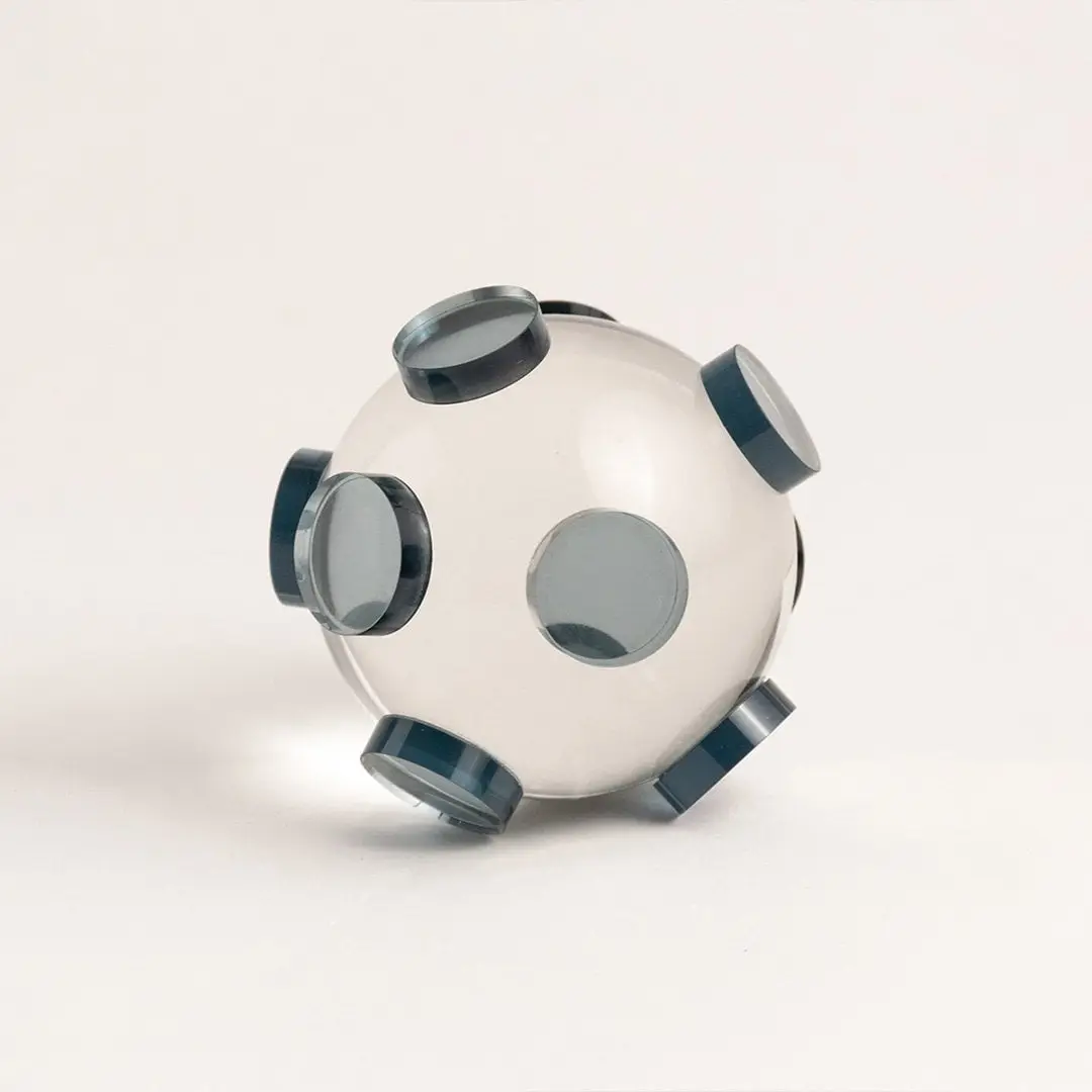 Clear glass orb sculpture with grey circular accents displayed on white background for modern home styling.