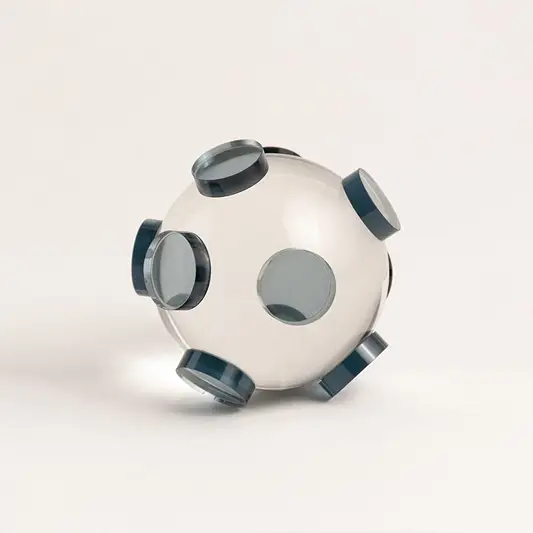 Clear glass orb sculpture with grey circular accents displayed on white background for modern home styling.