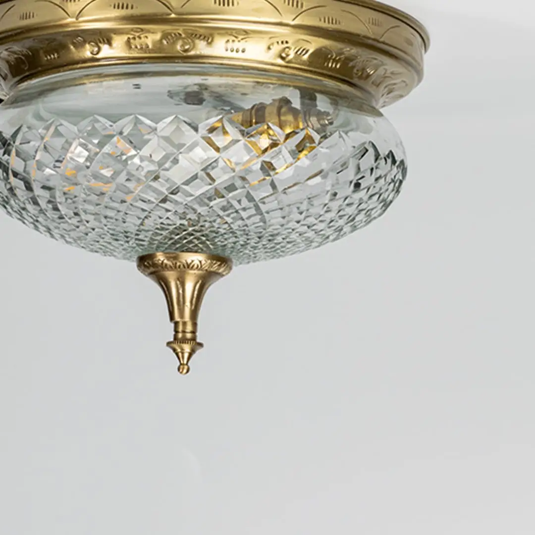 Closeup of antique brass and cut crystal flush mount ceiling light for luxury traditional interior decor styling spaces.