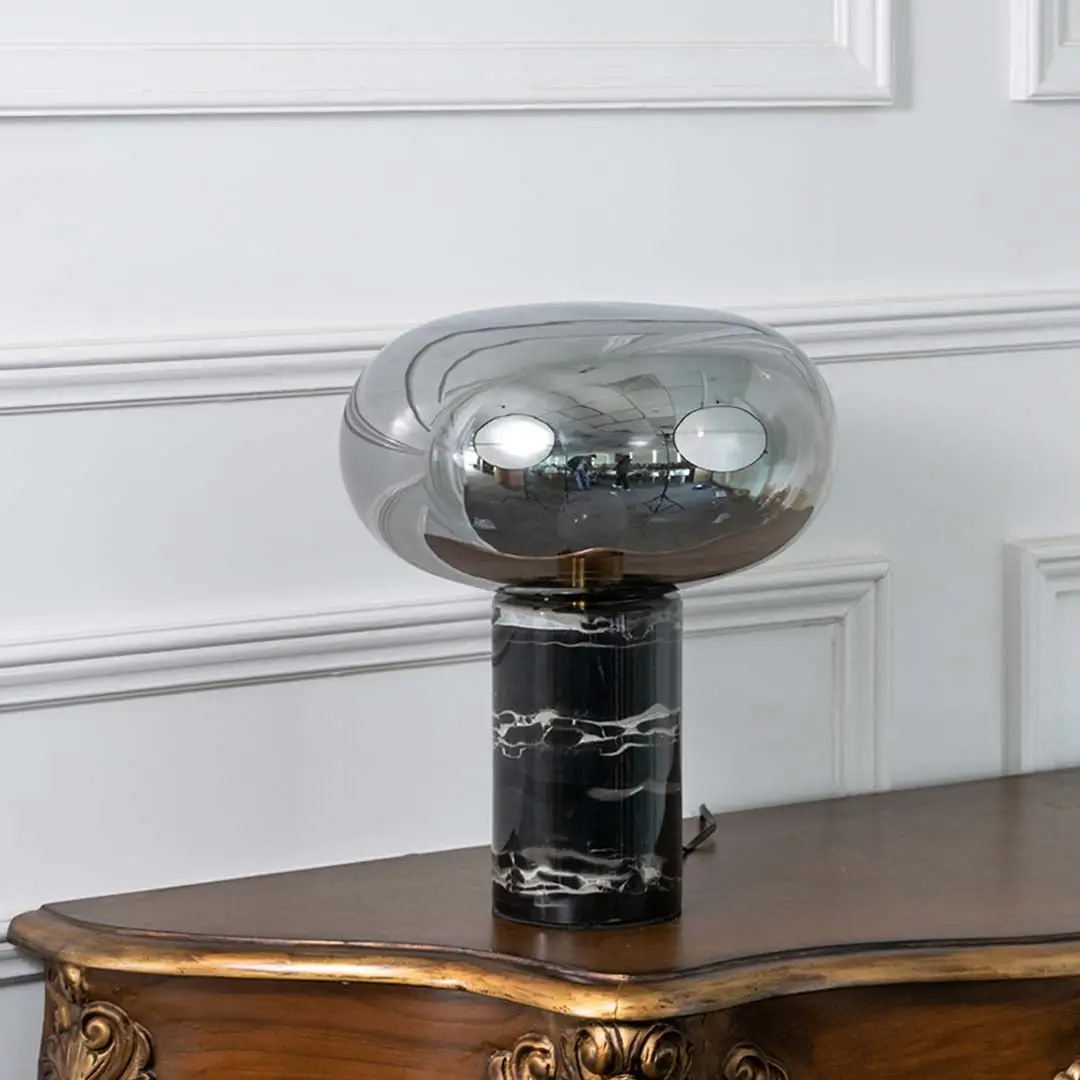 Elegant smoked glass table lamp with a solid black marble base displayed on white background showcasing its sleek modern design.