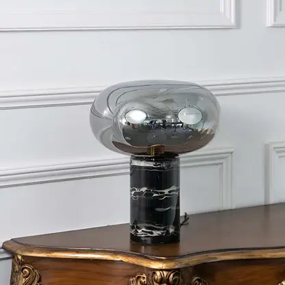 Elegant smoked glass table lamp with a solid black marble base displayed on white background showcasing its sleek modern design.