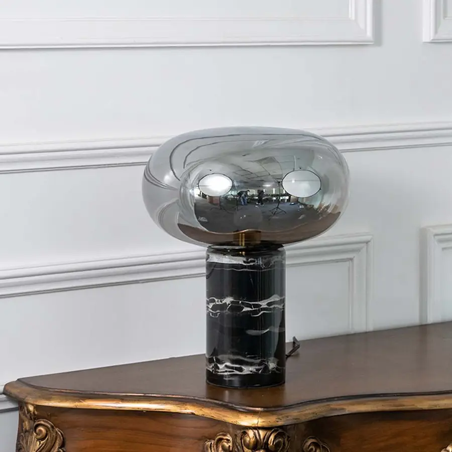 Elegant smoked glass table lamp with a solid black marble base displayed on white background showcasing its sleek modern design.