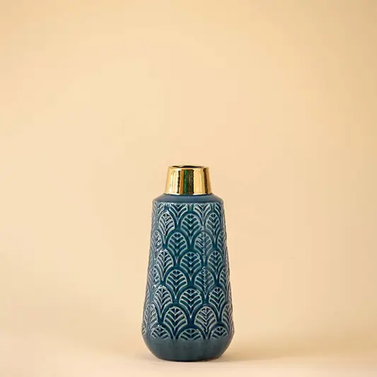 Blue textured ceramic vase with gold base accent perfect for modern table decor placement in living room or bedroom setting.