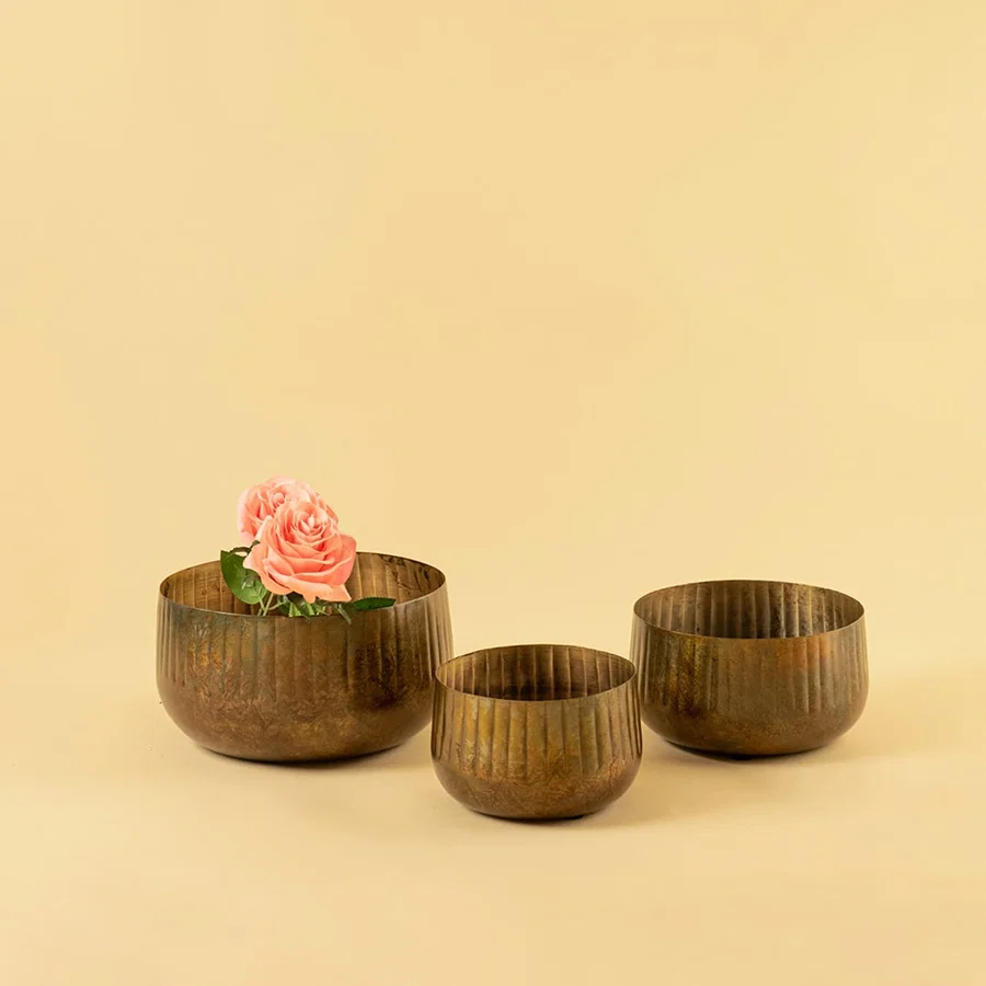 Bronze ribbed bowl planter shown with matching decor pieces offering a cohesive warm rustic look for home styling.