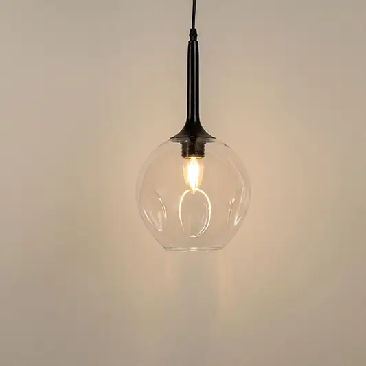 Clear glass pendant light with black holder and visible filament bulb modern minimal lighting for kitchen and dining decor.

