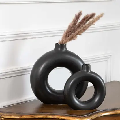 Set of two modern black ceramic donut vases with matte finish perfect for pampas grass and table decor styling.