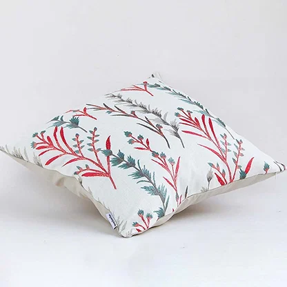 Soft cotton cushion cover with coral and teal botanical design shown at an angle creating a lively nature inspired décor accent with a breathable gentle and skin friendly fabric.