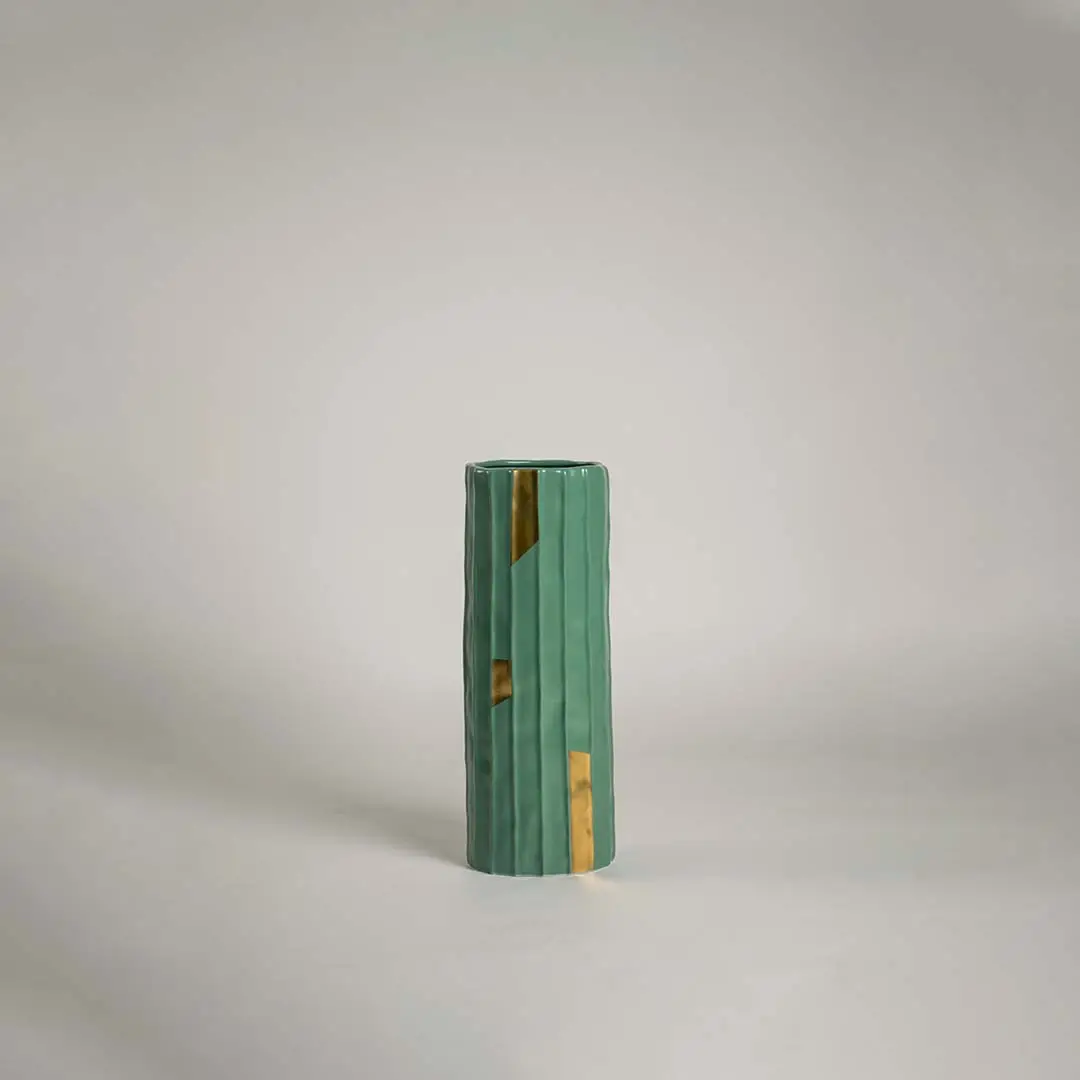Green ceramic decorative vase with gold accent detailing for shelf styling and contemporary home decor display.