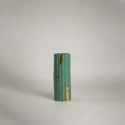 Green ceramic decorative vase with gold accent detailing for shelf styling and contemporary home decor display.