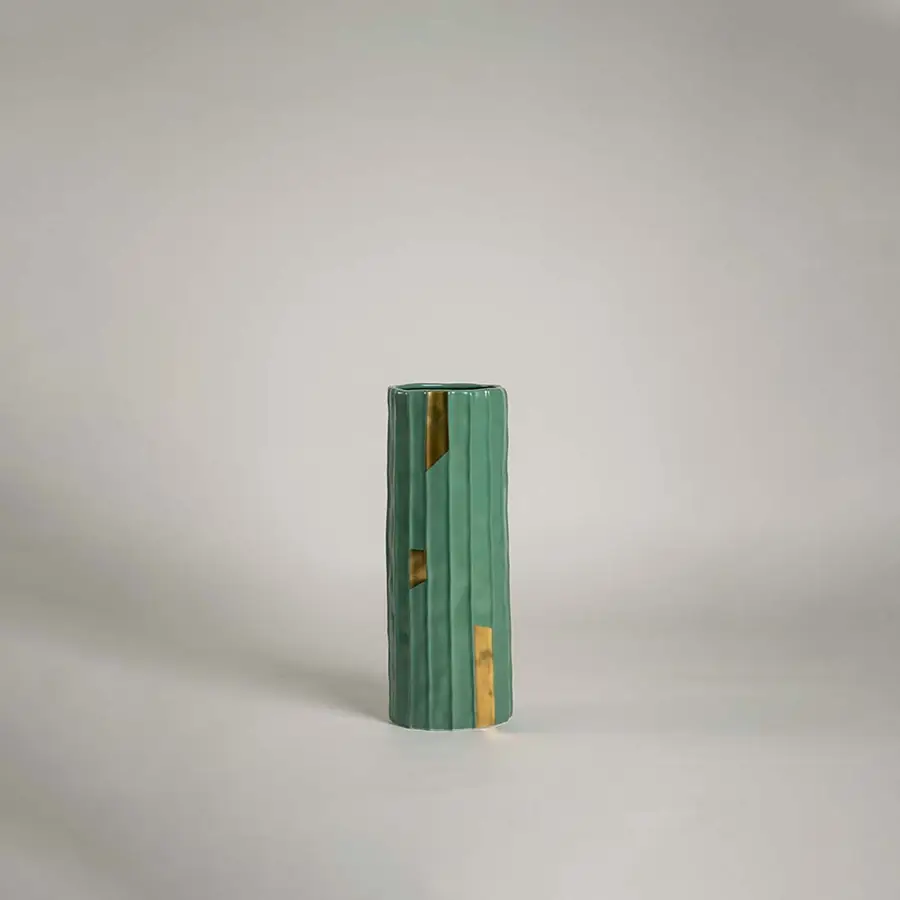 Green ceramic decorative vase with gold accent detailing for shelf styling and contemporary home decor display.