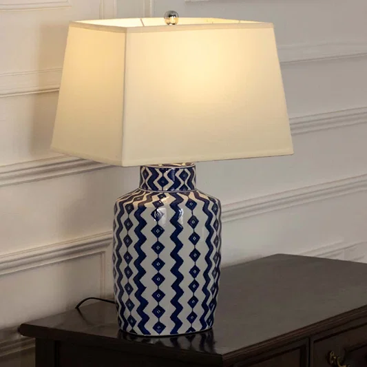 Blue and white ceramic table lamp with fabric shade creating timeless traditional decor and warm ambient lighting.