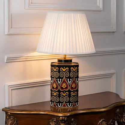 White shade table lamp featuring black and gold geometric ceramic base designed for luxury bedside and living room decor.