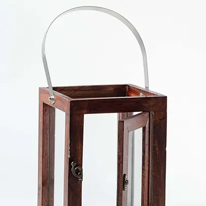 Closeup of wooden lantern with glass panels and silver handle highlighting fine craftsmanship and elegant finish.