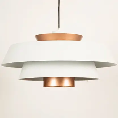 White and copper metal pendant light closeup showcasing layered design and premium finish.