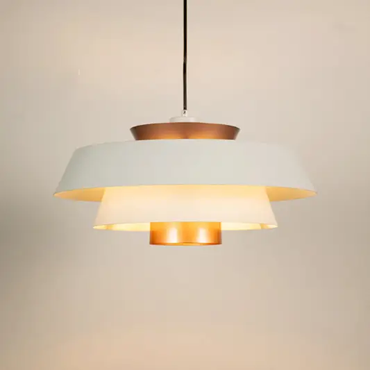 White and copper metal pendant light glowing warmly on white background creating stylish ambience for home office cafe and more spaces.