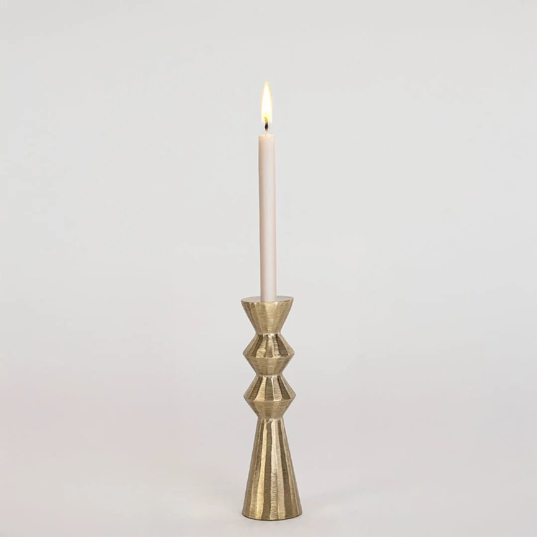 Modern gold metal candle holder with sculpted geometric design displayed on a clean white background for decor.