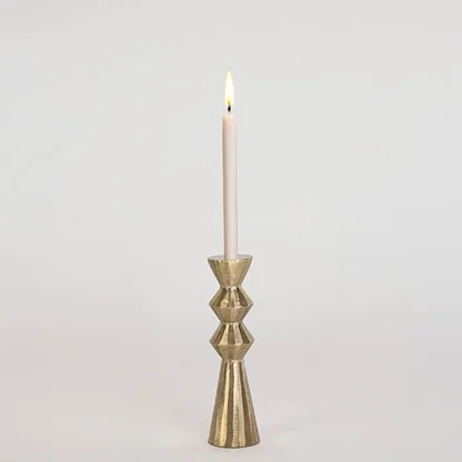 Modern gold metal candle holder with sculpted geometric design displayed on a clean white background for decor.