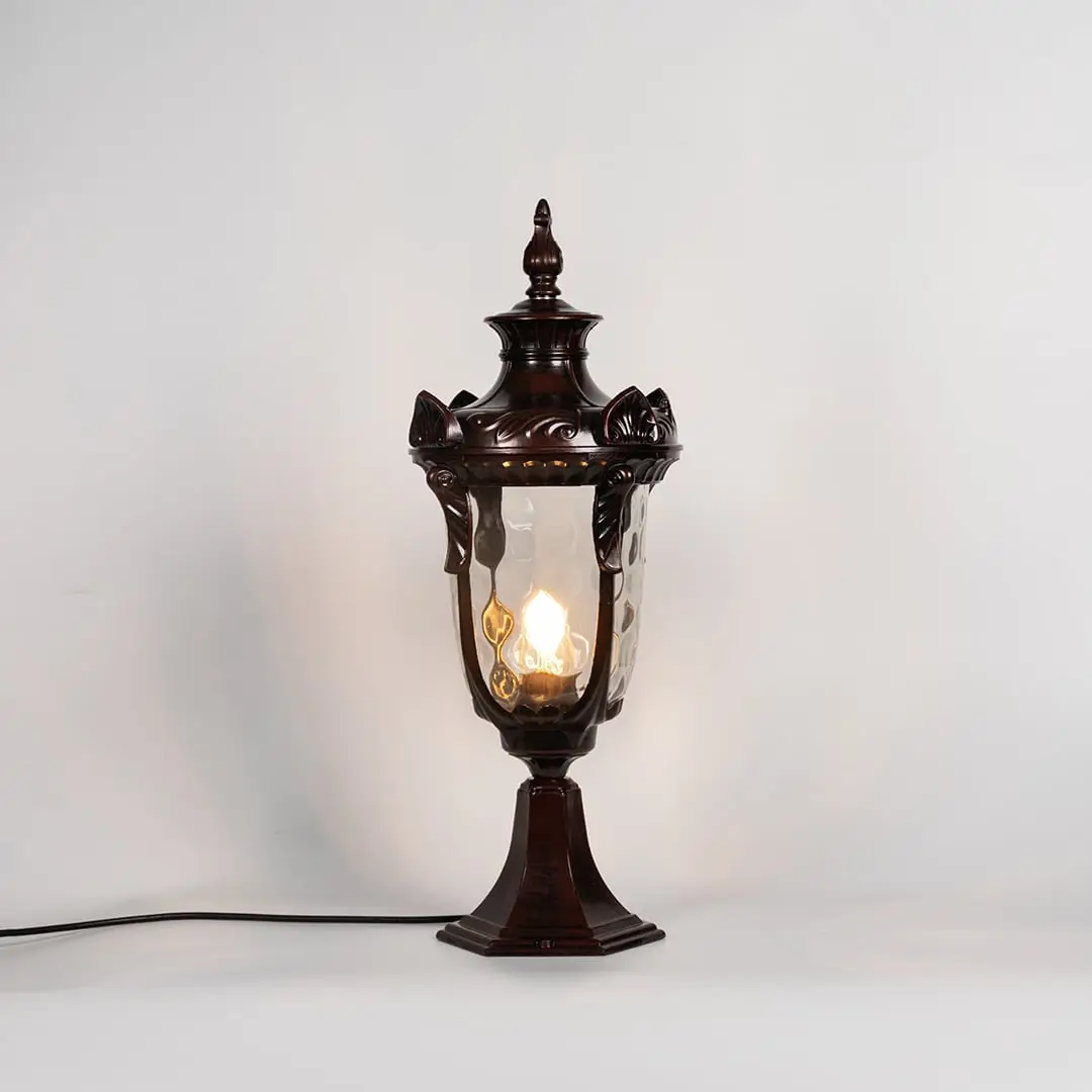 Brown pillar lamp glowing with warm bulb and glass panels shown on white background for stylish outdoor garden lighting.