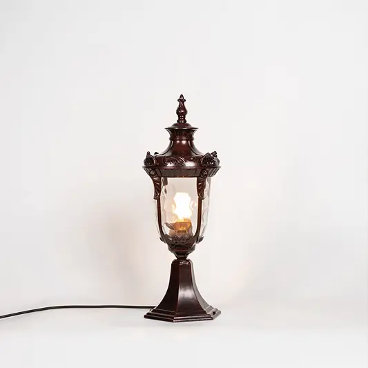 Classic outdoor gate light with antique brown metal finish and glowing glass shade for decor styling.
