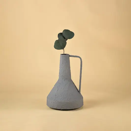 Sleek matte grey metal vase with handle and leaf stem for contemporary minimalist home interior decor accents.
