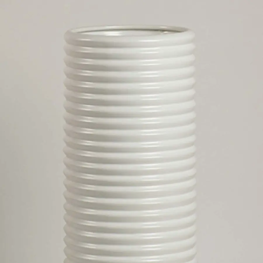 Closeup of white ceramic vase showing ribbed detailing and smooth handcrafted finish for minimalist artistic appeal.