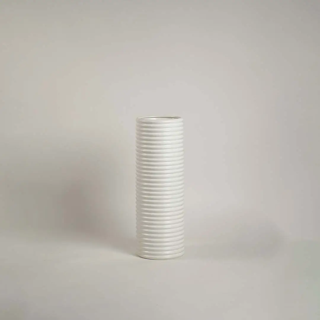 Matte white ceramic cylinder vase featuring a dense horizontal ribbed stacked texture on a clean white background.