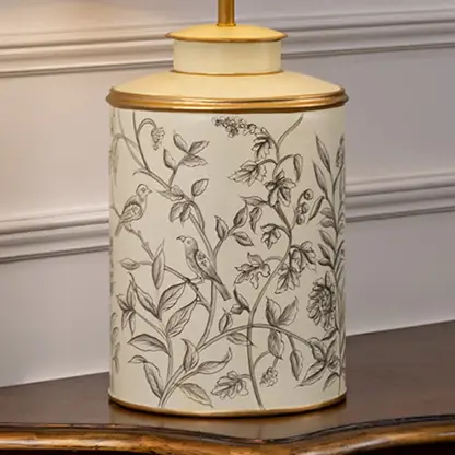 Table lamp closeup highlighting delicate botanical artwork on ceramic base with fine line detailing and smooth glazed finish.