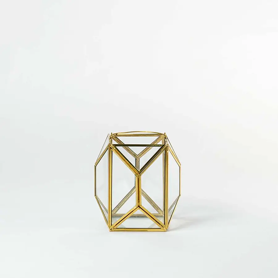 Gold metal geometric candle holder with open frame structure for modern tabletop decor styling.