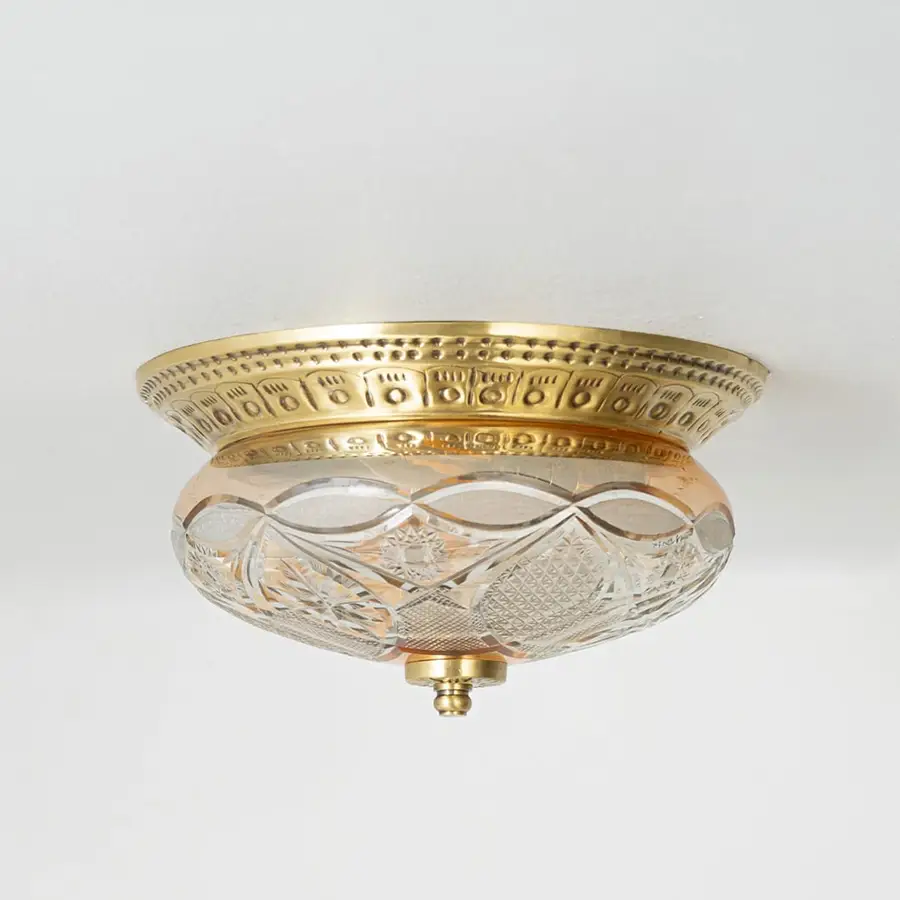 Vintage brass and glass flush ceiling light installed on white ceiling adding classic charm to home interior setting.