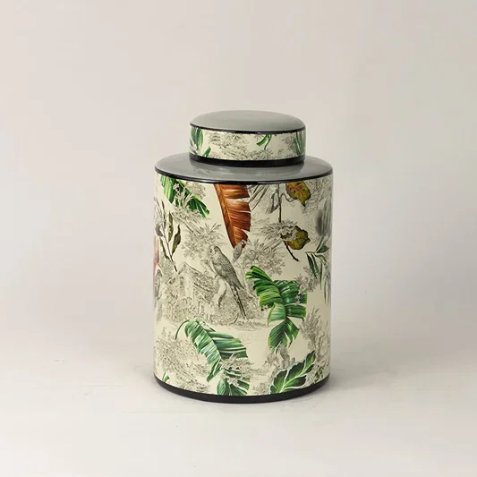 Tropical bird jar captured from side angle showing curved body and detailed bird and leaf artwork.