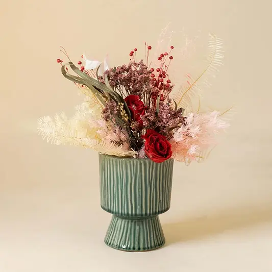 Stylish ribbed green ceramic vase placed in bright interior setup adding artistic charm to modern home styling.