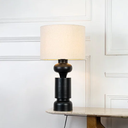 Classic table lamp in black base with fabric shade for bedside or living room decor lighting placement white background.