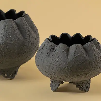 Closeup of grey metal scalloped bowl planter showing textured detailing and ornate base perfect for stylish home decor accents.