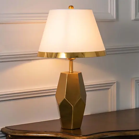 Brown geometric ceramic table lamp with fabric shade creating warm ambient lighting and sophisticated modern decor appeal.