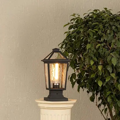 Black metal outdoor post lantern with light on Warm ambient lighting on a decorative pillar Main Lifestyle image.