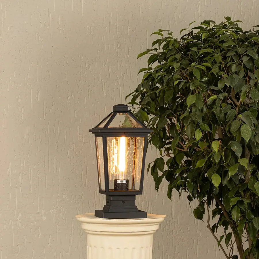 Black metal outdoor post lantern with light on Warm ambient lighting on a decorative pillar Main Lifestyle image.