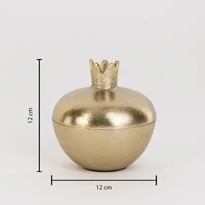 Gold metal pomegranate jar measuring 12 cm tall and 12 cm wide with crown lid and glossy finish shown on white wall