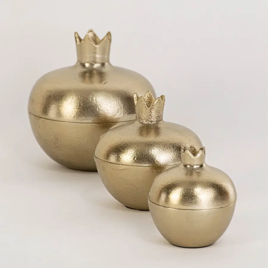 Compact gold pomegranate storage jar featured in cozy interior perfect for seasonal table decor or small keepsakes