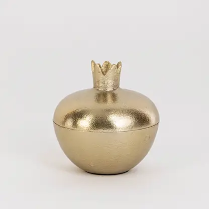 Smooth gold pomegranate-shaped jar with crown top shown on clean white background for clear product presentation