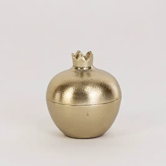 Mini gold pomegranate jar shown in room setup without white background adding subtle accent to home decor styling