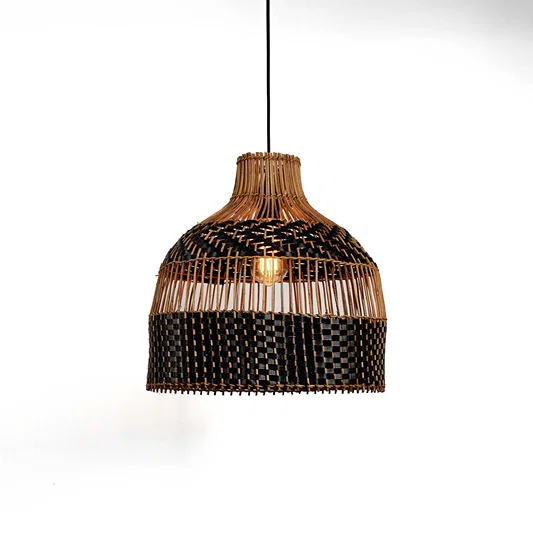 Handwoven rattan pendant light with layered fringe detail and black accent band hanging against soft neutral wall background for boho decor styling.