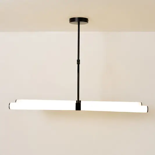 Warm-lit chandelier against a clean white background showcasing its modern linear design and suspended structure.