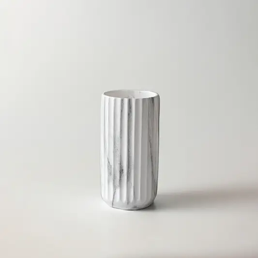 White ceramic decorative vase with vertical ribbed texture for shelf styling and contemporary home decor displays.