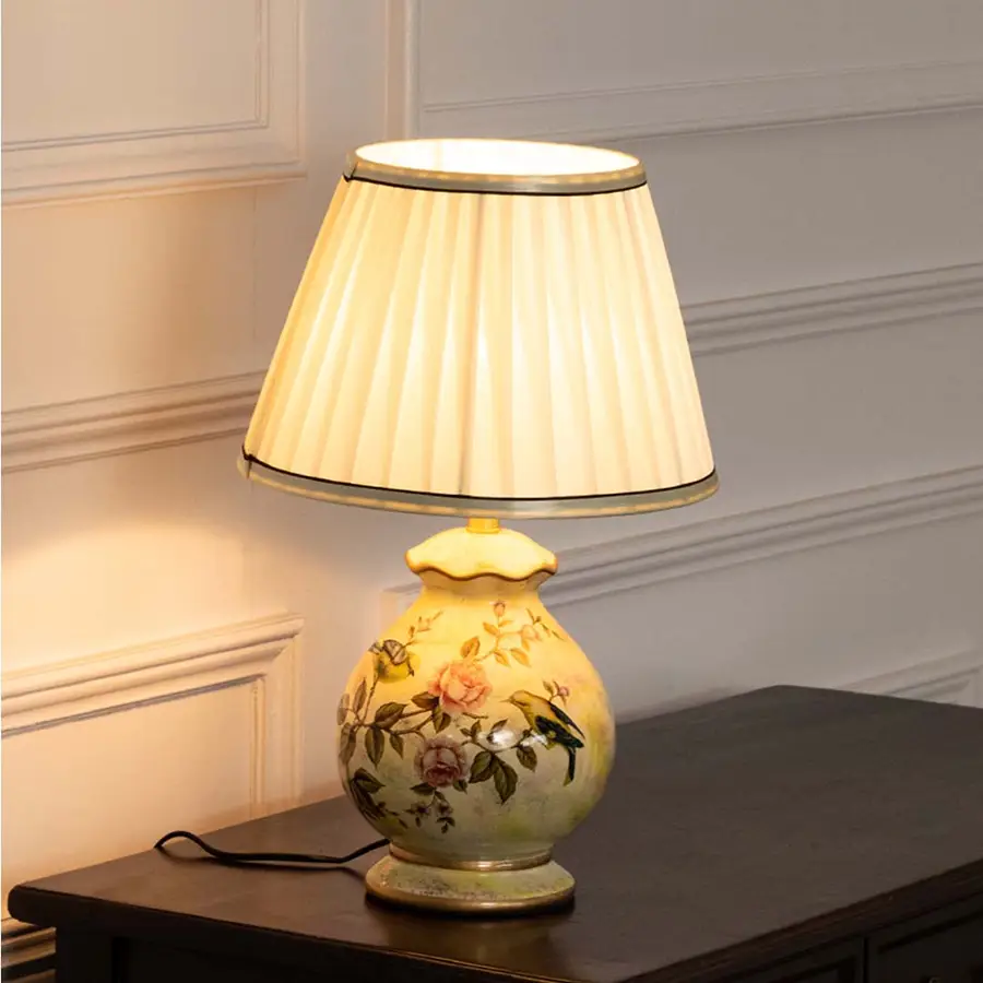 Yellow floral ceramic table lamp with pleated fabric shade offering warm traditional lighting and timeless decor appeal.