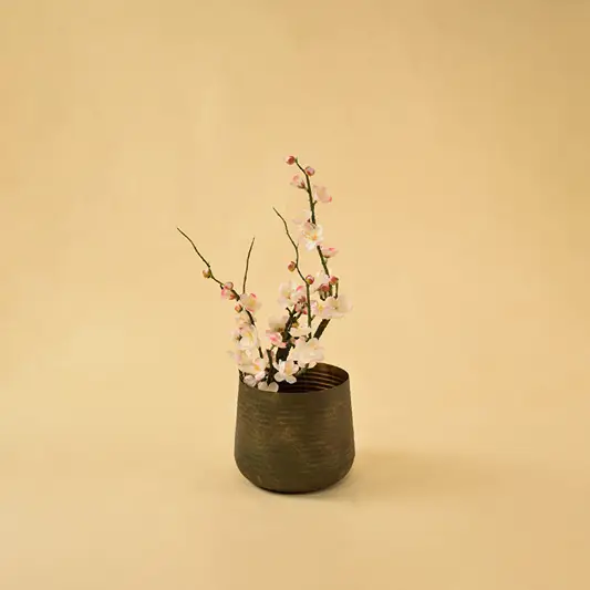 Metallic bronze bud vase with floral stem for luxury modern home decor and artistic tabletop centerpieces.
