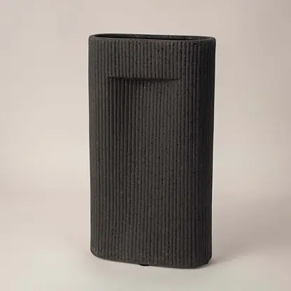 Side angle view of black rectangular ceramic vase with grooved texture perfect for living room or office interior styling.
