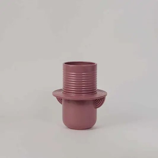 Mauve ceramic decorative vase with ribbed texture and sculptural form for modern shelf styling and home decor.