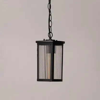 Black metal lantern with ribbed glass shown on white background displaying sleek outdoor lighting design.
